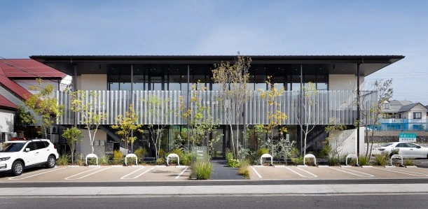昼間の宮池テラス。ガラス面と植栽のある建物の外観